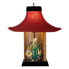 a lamp with a red shade on top of it and a buddha figurine