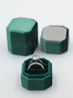 an engagement ring in a green velvet box with two matching bands on the inside and outside