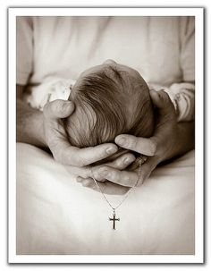 a person holding a baby in their arms with a cross on it's chest