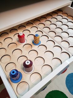 an open drawer with some thread and spools on it