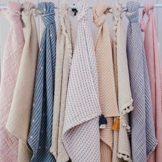 several different colored towels hanging on a rack