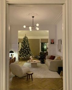 a living room filled with furniture and a christmas tree in the middle of the room