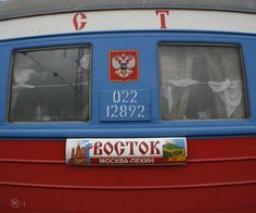 the side of a bus with russian writing on it's windows and an emblem