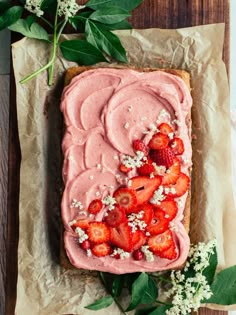 a piece of cake with strawberries on it and some flowers around the edge,