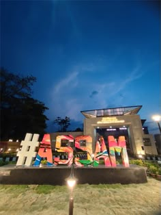 the entrance to an art museum with graffiti on it's letters and lights at night