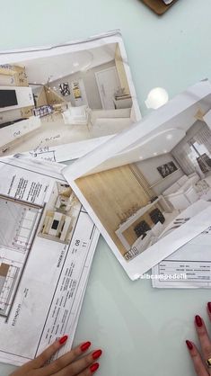 a woman's hands on top of architectural drawings and plans for a kitchen area