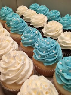 cupcakes with blue and white frosting in a box