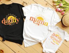 two shirts with the words daddy and mama printed on them next to a straw hat