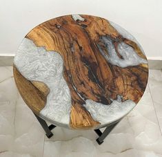 a wooden table sitting on top of a tiled floor next to a white and black wall