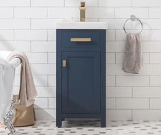 a bathroom with white tile and blue cabinet