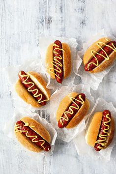 four hot dogs with mustard and ketchup on them