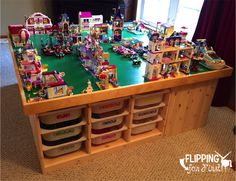 a table with many toy figurines sitting on it's sides in front of a window