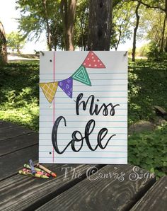 a sign that says miss cole on it next to some crayons and markers