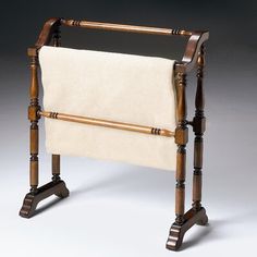 an old fashioned wooden chair with a white blanket on it's back and legs