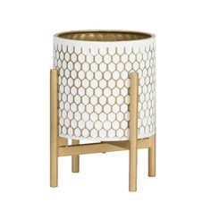 a white and gold planter sitting on top of a wooden stand with two legs