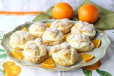 oranges and pastries on a plate with powdered sugar