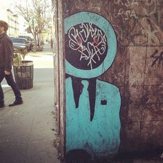 a man walking past a wall with graffiti on it