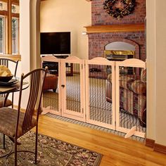 a living room with a fireplace, dining table and dog kennels in it