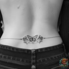 a black and white photo of a woman's back with butterflies on her stomach