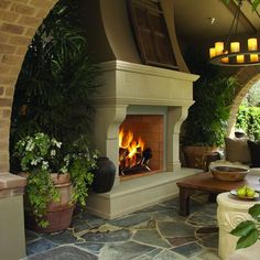 a living room with a fire place and potted plants