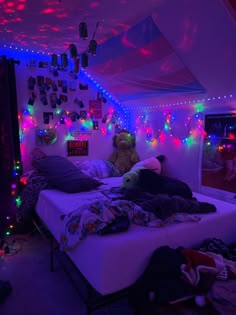 a bedroom with purple lights and stuffed animals on the bed in front of it's headboard