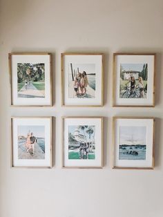 four framed photographs hang on the wall above a bed