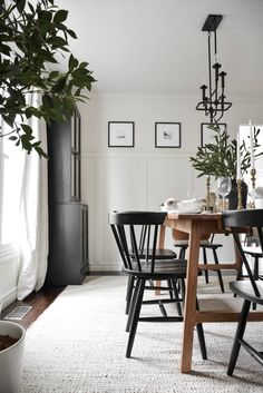 a dining room table with black chairs and a potted plant