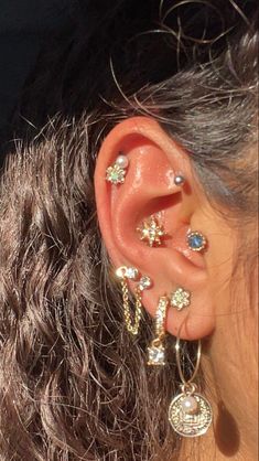 a close up of a person's ear with multiple piercings on it,