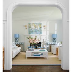 a living room filled with furniture and a fire place under a painting on the wall