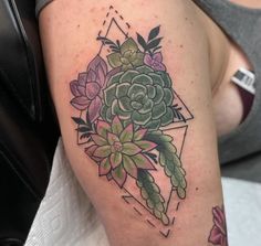 a close up of a person's arm with a tattoo on it and succulents