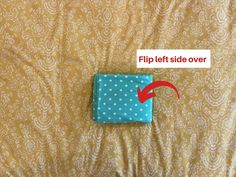 a piece of cloth with a red arrow pointing to the left side of it on a bed