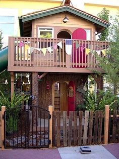 a small wooden house with a balcony and balconies on the top floor is decorated with bunting