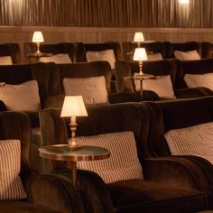 rows of chairs with lamps on them in a movie theater