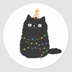 a black cat sitting on top of a christmas tree