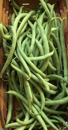 a basket filled with green beans sitting on top of a table