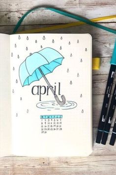 an open notebook with the word april written on it next to markers and pencils