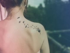 a woman with a dandelion tattoo on her back