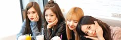 three young women sitting at a table with drinks and donuts in front of them