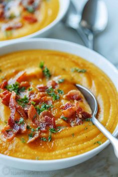 two bowls filled with soup and topped with bacon