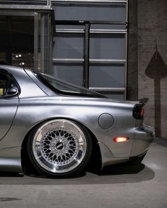 a silver sports car parked in front of a building