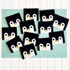 penguins made out of felt sitting on top of a cutting board