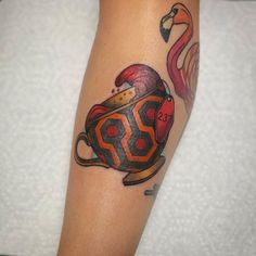 a tattoo on the leg of a woman with a teapot and flamingos