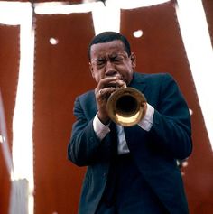 a man in a suit and tie playing a trumpet