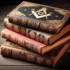 three books stacked on top of each other in front of a black background with an masonic symbol