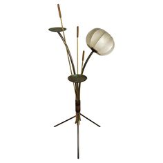 a lamp that is on top of a tripod with three lights in it and two sticks sticking out of the base