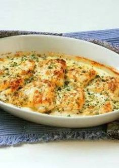 a casserole dish with cheese and broccoli in it on a blue towel