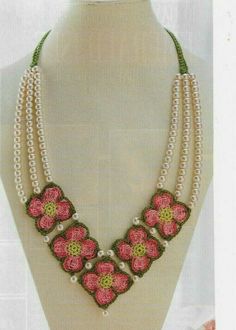 a necklace with pink flowers and pearls on it