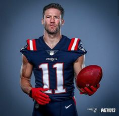 a man holding a football in his right hand and posing for a photo with the ball