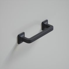 a black towel ring on a white wall