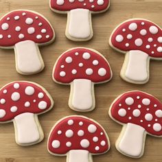 cookies decorated with red and white mushrooms on a wooden table, ready to be eaten